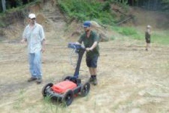 Two people using a ground penetrating radar machine