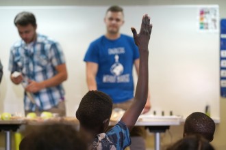 A student at the Refugee Education Center raises his hand during a class by WMU engineering students.