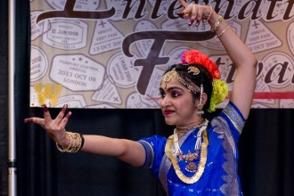 A female Indian student dancing in traditional clothes.