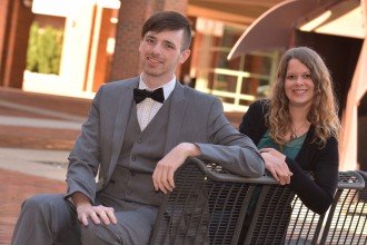 Avery Green and Desi Taylor sitting on a bench outside Schneider Hall, home of the WMU Haworth College of Business.