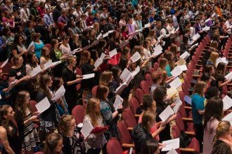 Dozens of high school students sing in Miller Auditiorium.