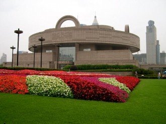 Photo of the Shanghai Museum of Ancient Art building surrounded by colorful flowers.