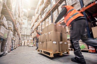 Photo of men moving boxes in a warehouse.