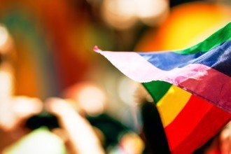 Photo of a rainbow flag at a gathering.