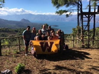 Group of WMU students with the WMU flag in front of Lake Atitlan, Guatemala