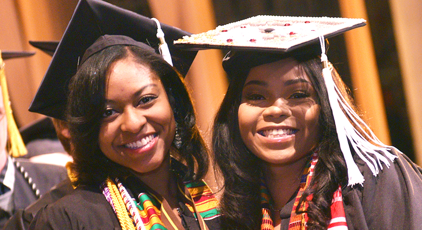 WMU student Kendall Owens and a friend smile in their graduation regalia