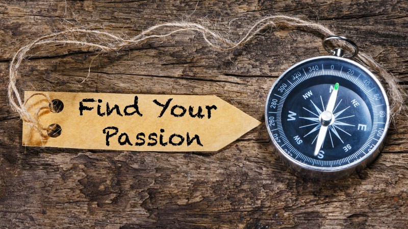 A compass attached to a slip of paper that reads "find your passion."