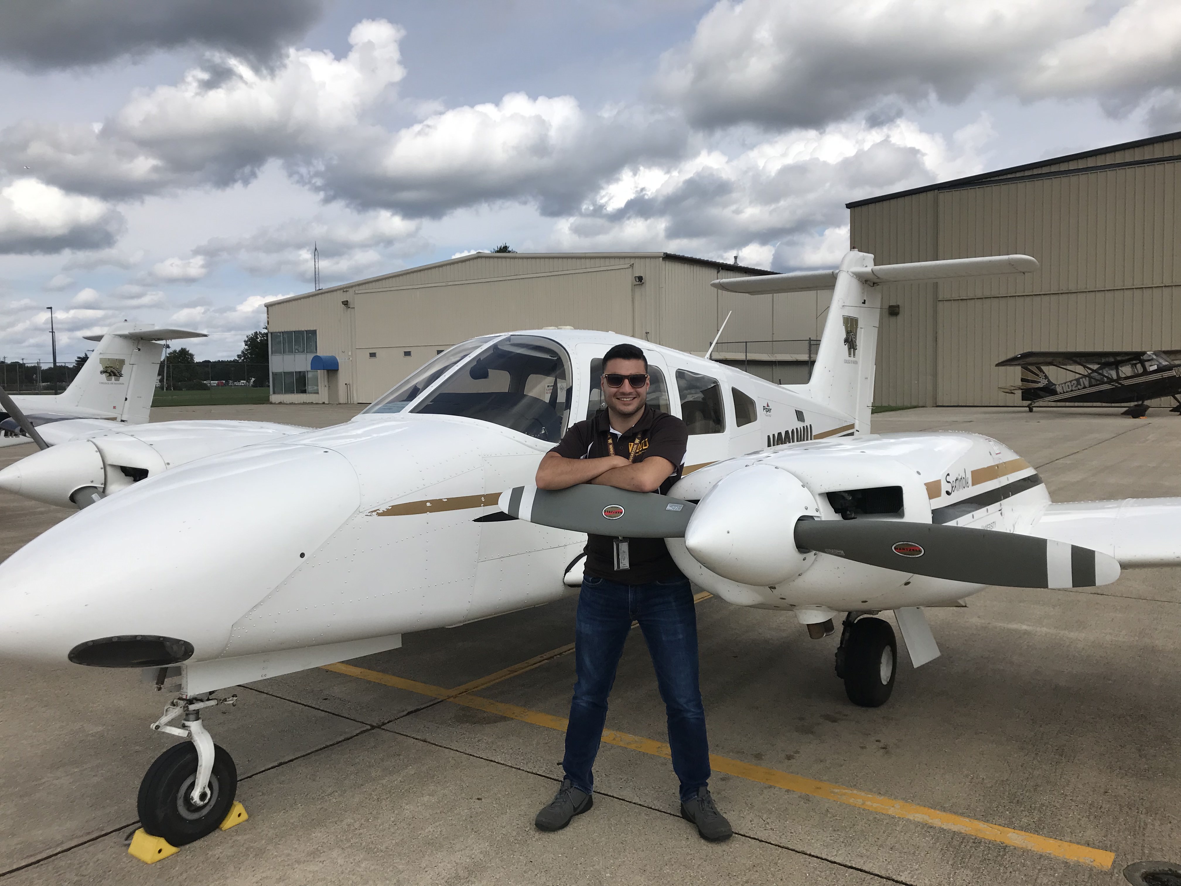 WMU Aviation Student - Trevor Thelen standing in front of a College of Aviation Piper Seminole