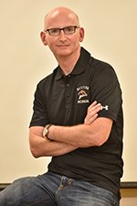 Michael Braun poses in classroom with his arm crossed