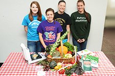 Dietetic students in front of fruits and vegetables.