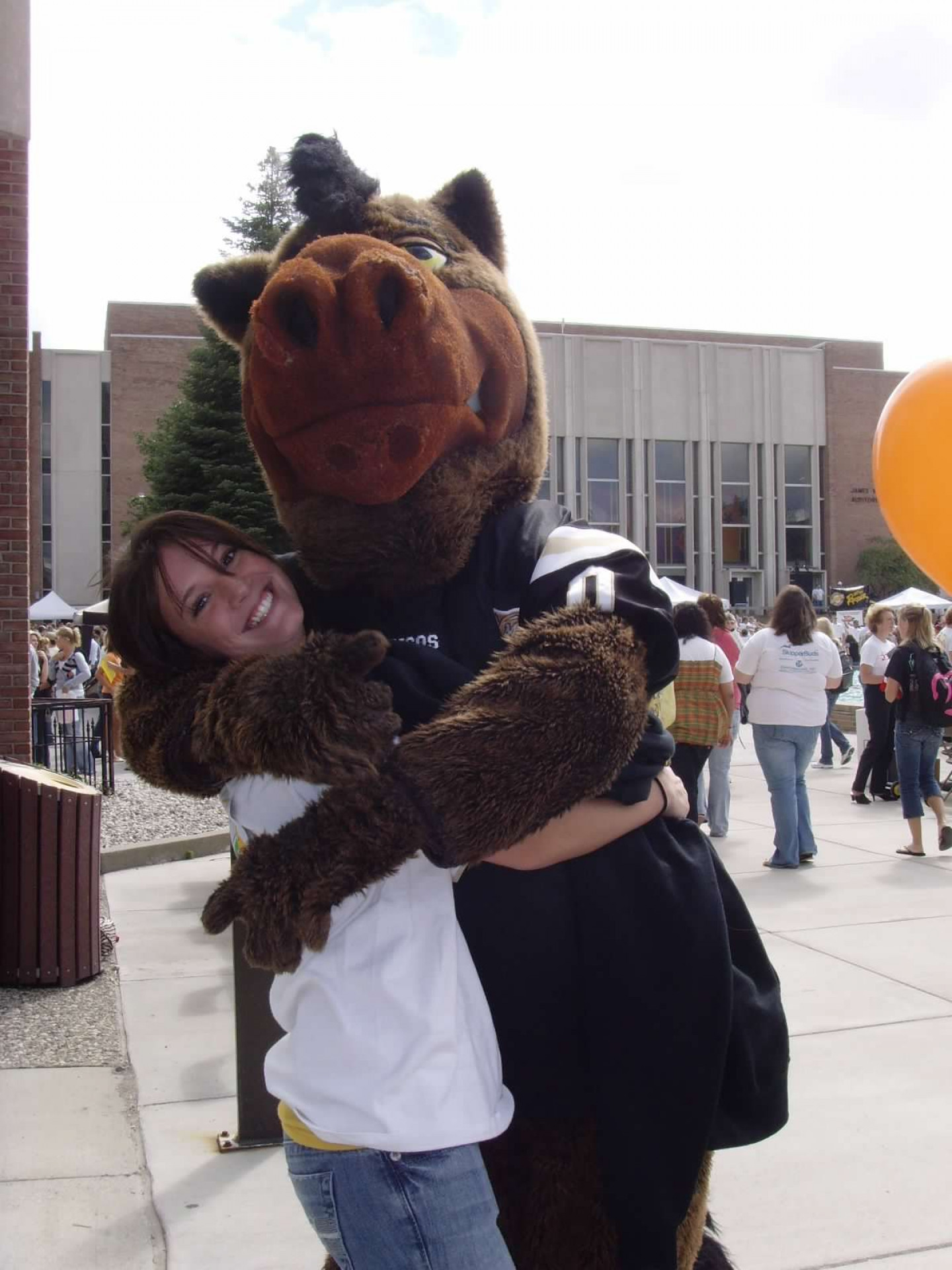 A student and Buster Bronco hugging each other.