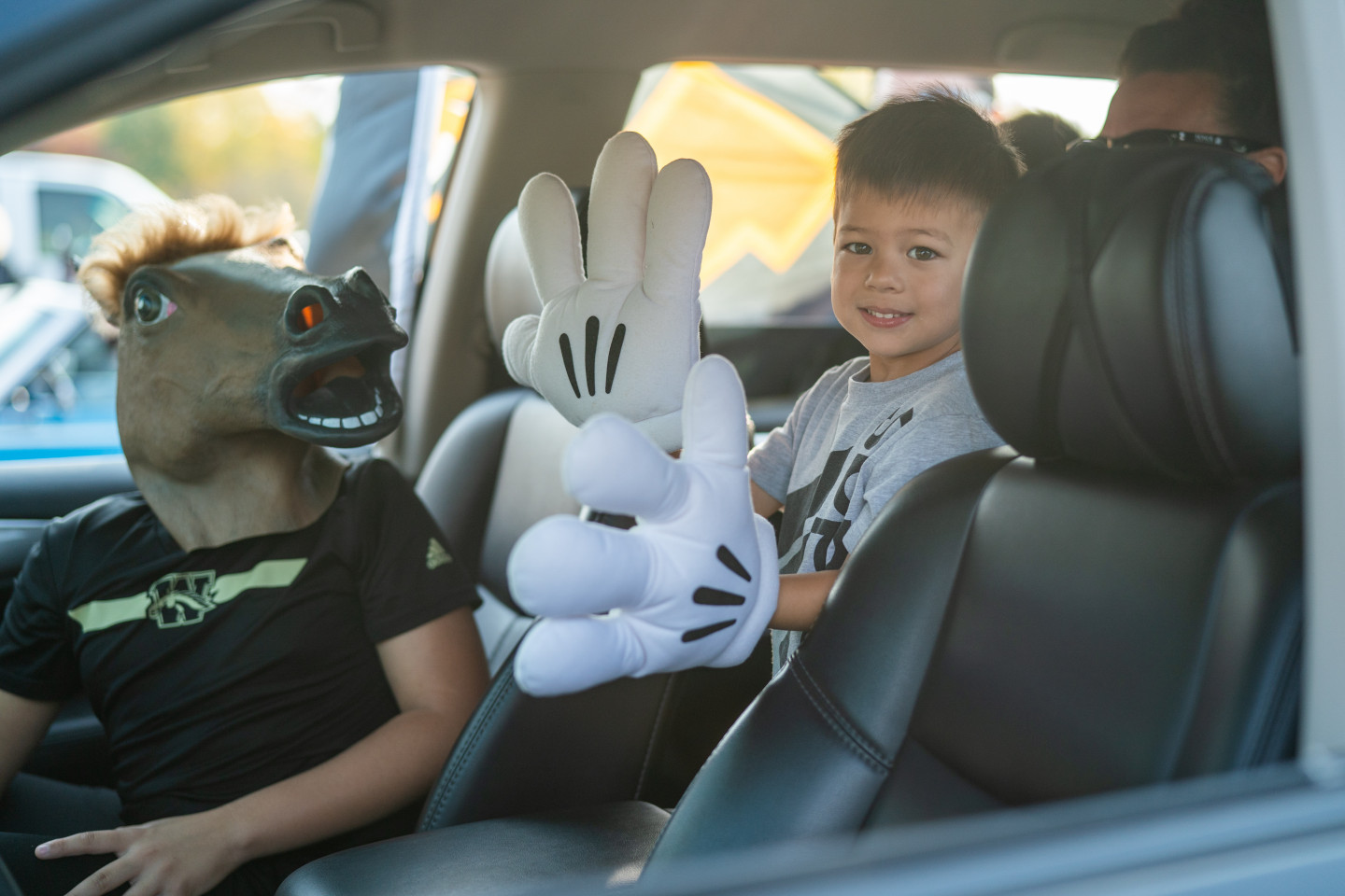 A young Bronco fan wearing large Mickey Mouse gloves.