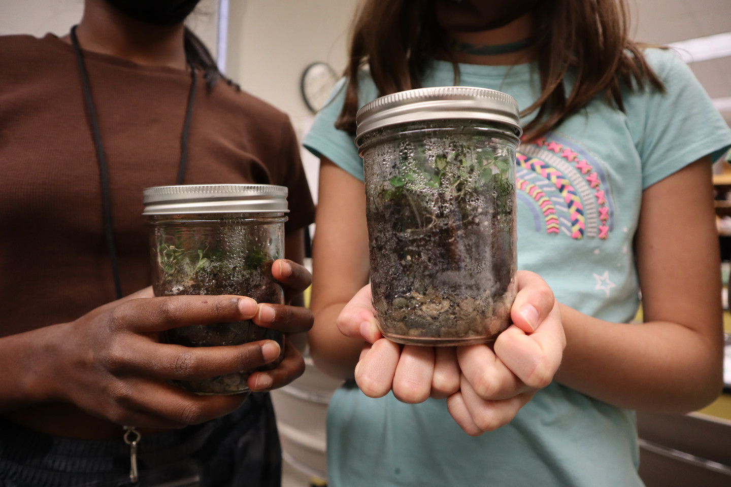 Students hold terrariums.
