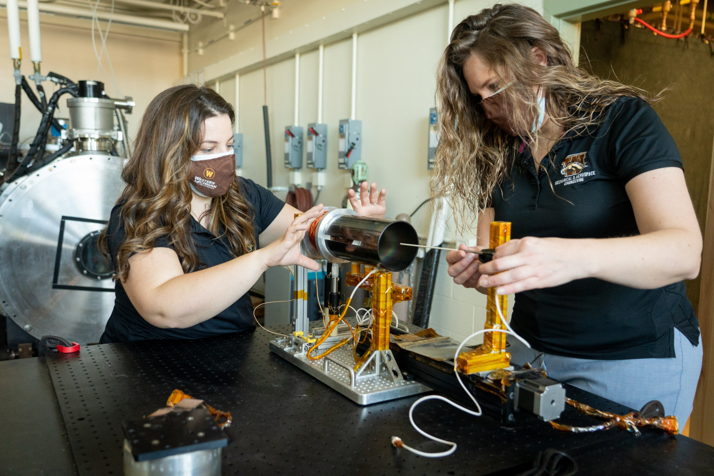 Margaret Mooney and Kristina Lemmer work on a device in a laboratory.