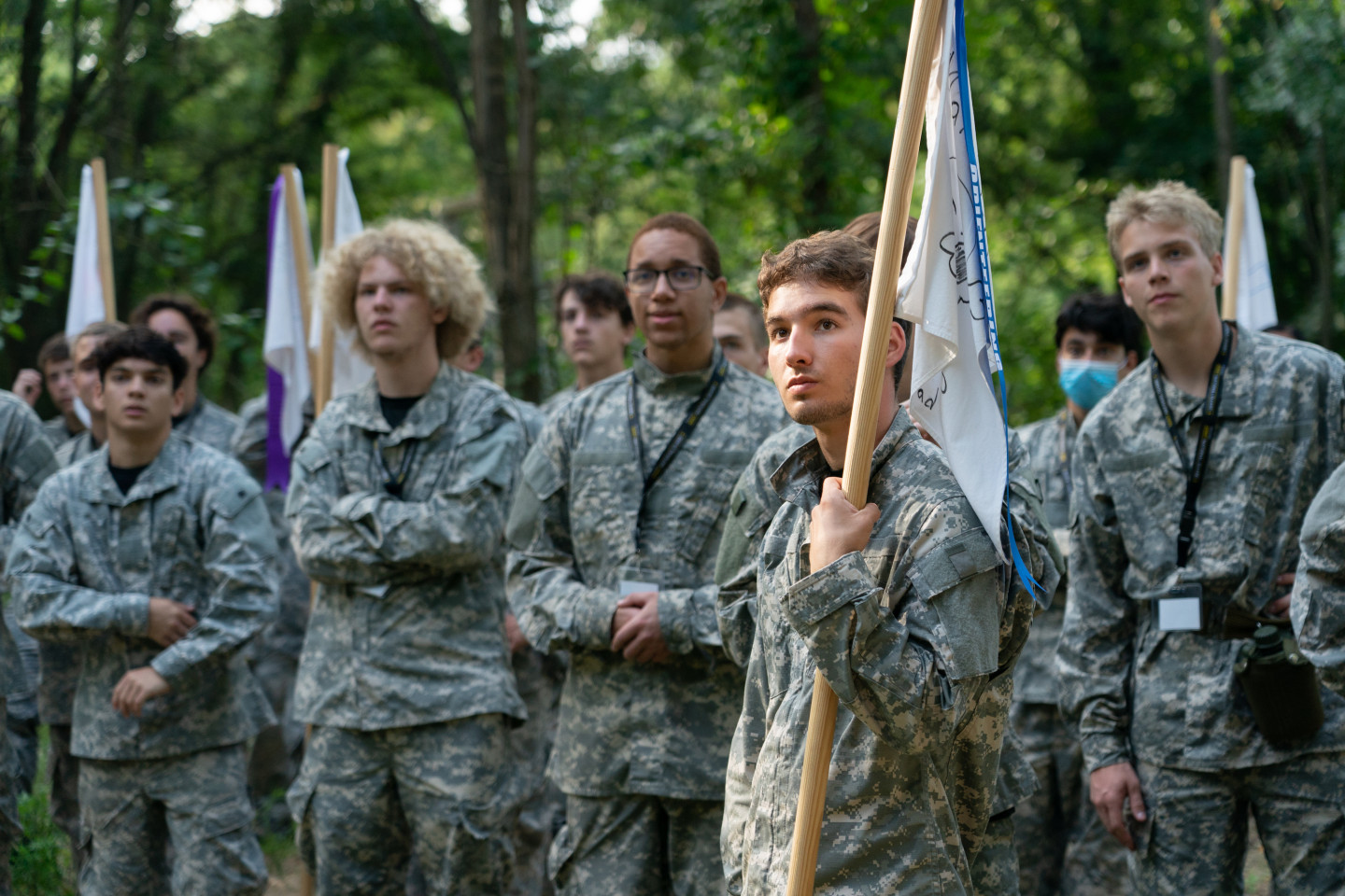 A group of teenagers dressed in Army fatigues stands together.