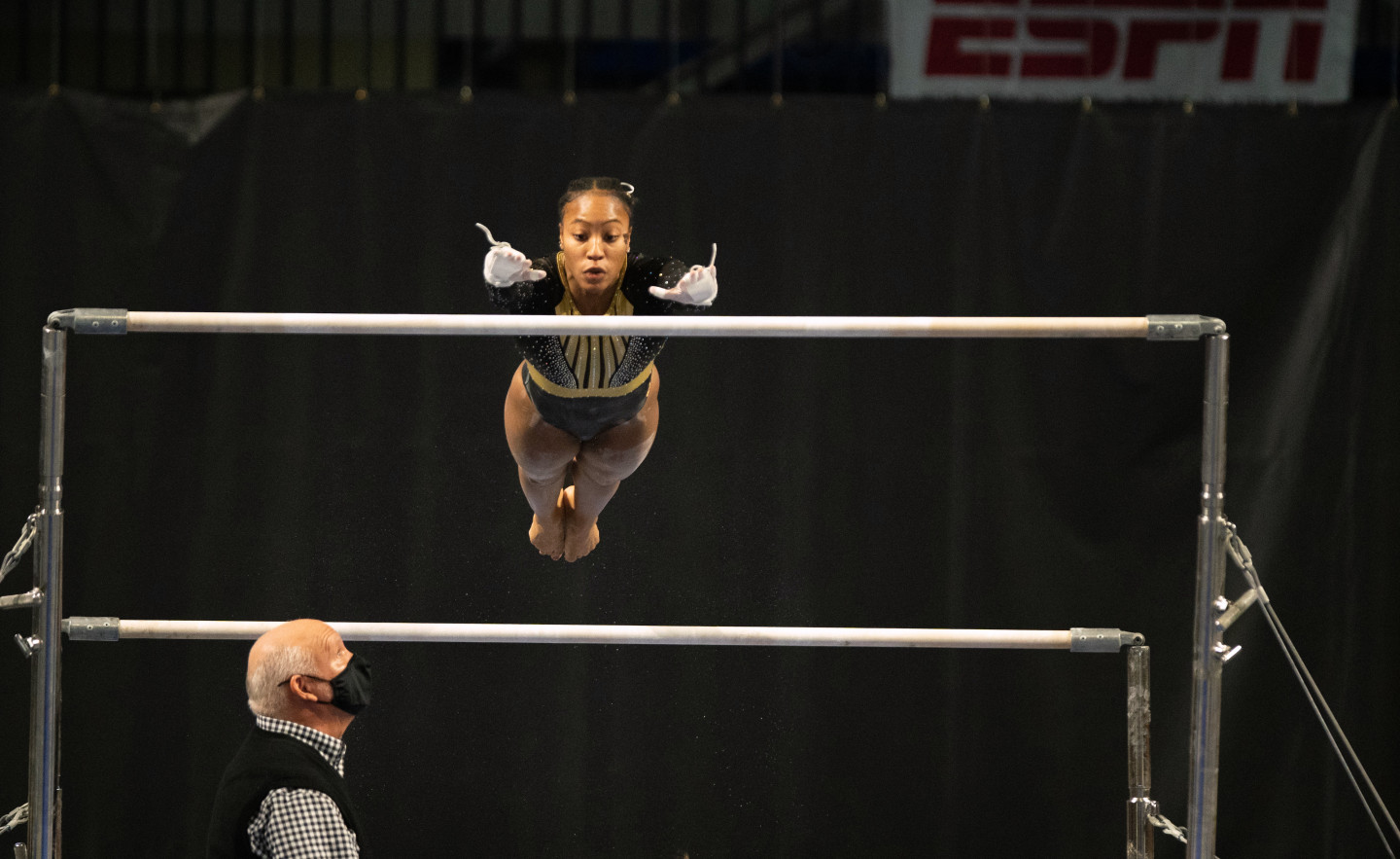 Stacie Harrison prepares to grab one of the uneven bars in a gymnastics competition.