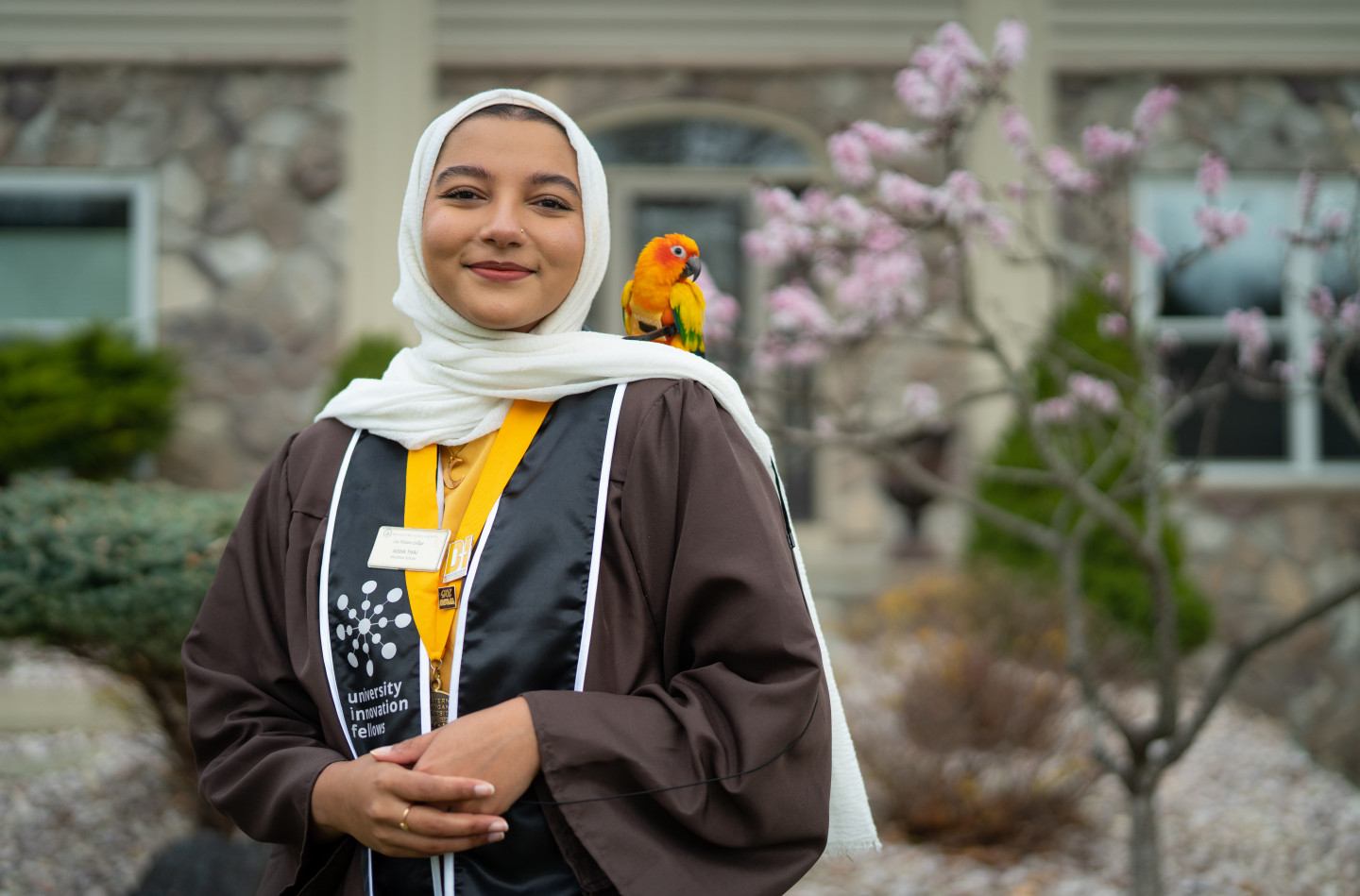 Aisha Thaj poses with her pet bird on her shoulder.