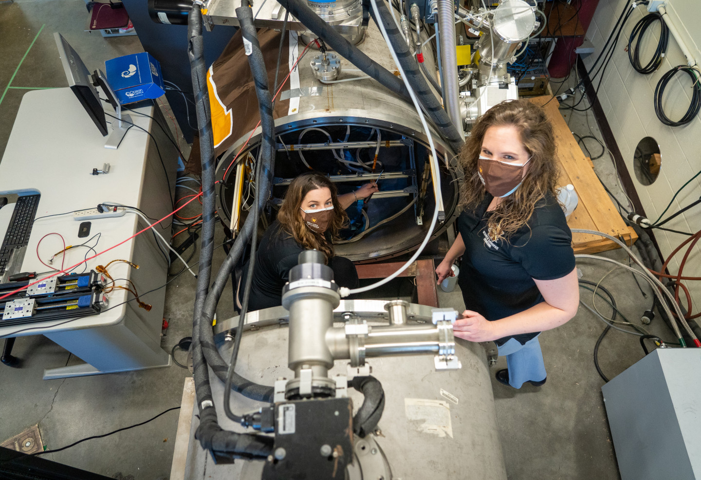 Two scientists in a large machine.