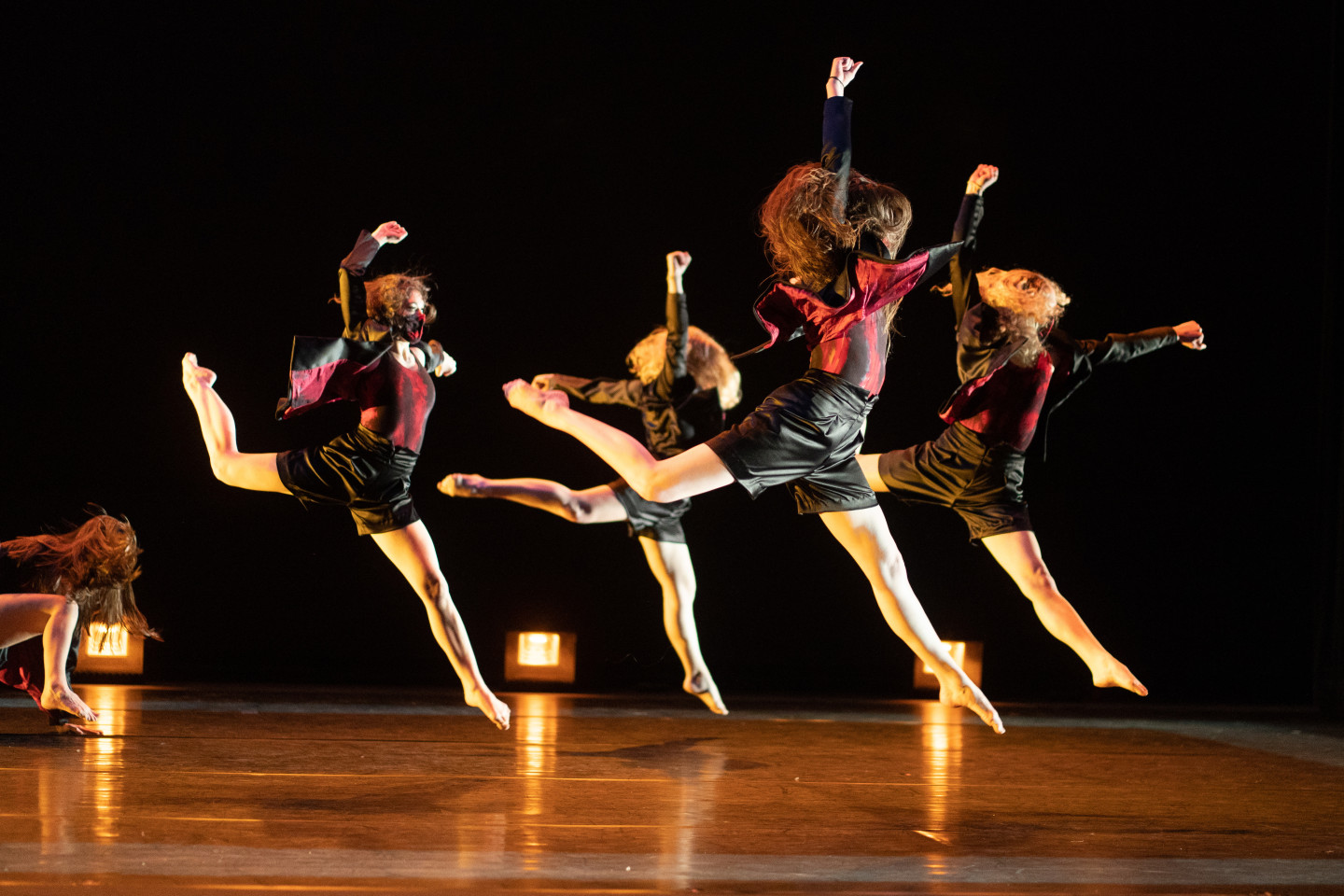 Dancers perform on stage.