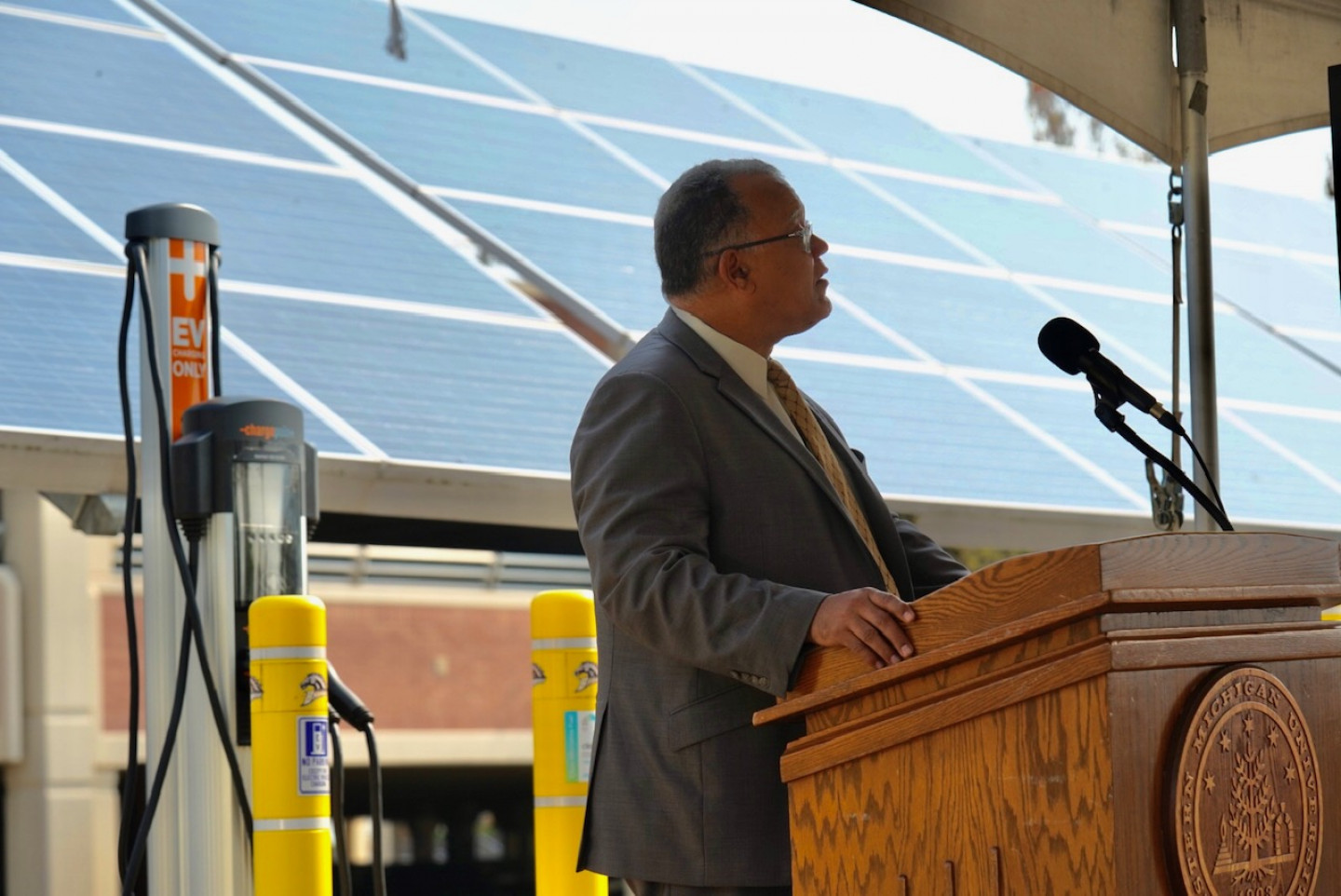 Edward Montgomery stands at a podium in front of a charging station.