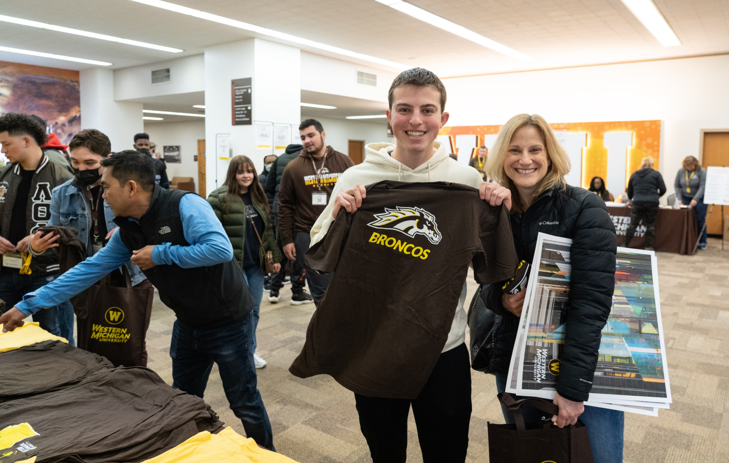 A student holds up a t-shirt.