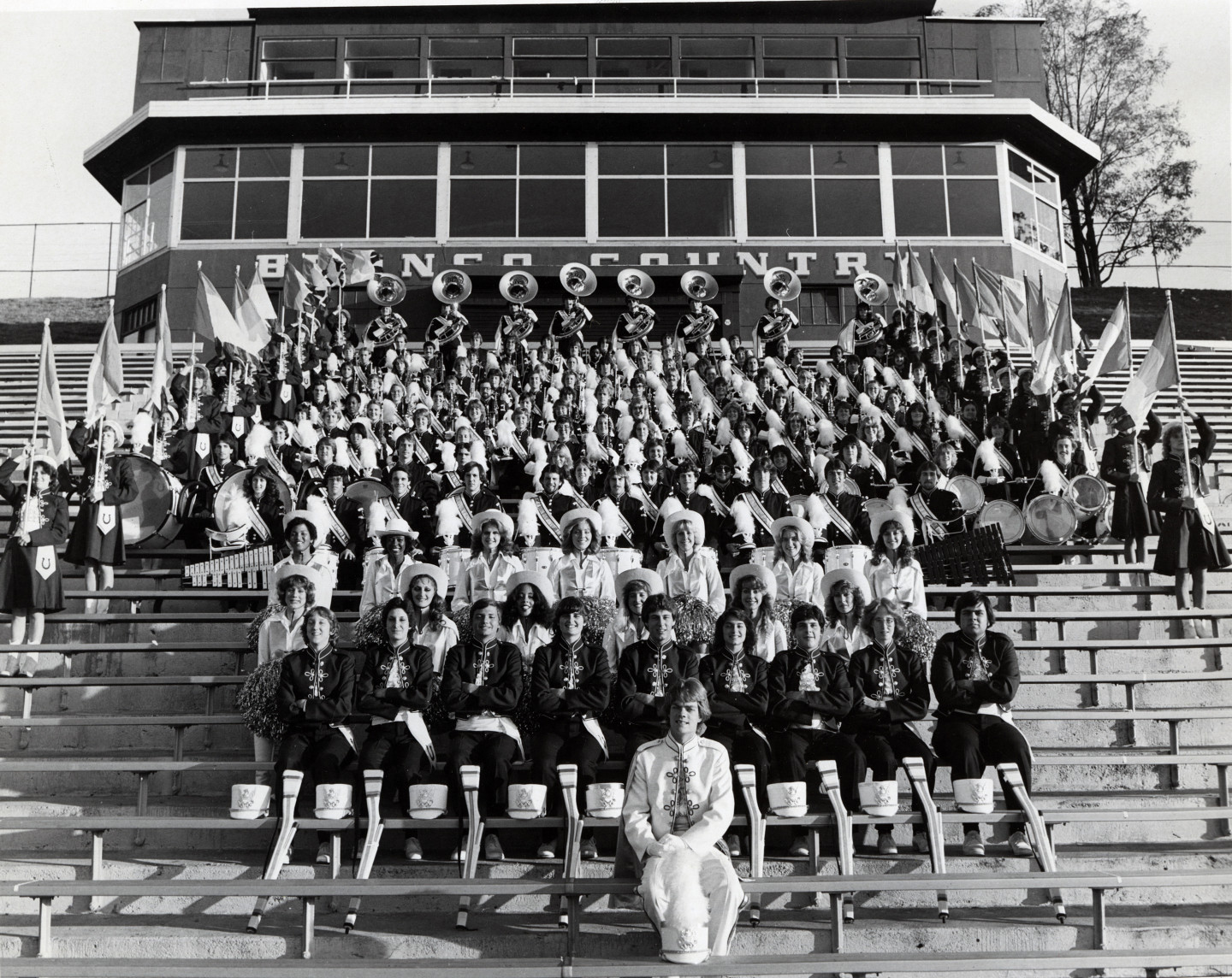Members of the Bronco Marching Band sit on bleachers.