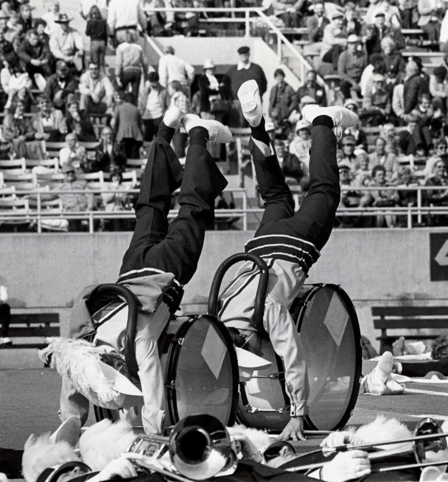 Marching band members do hand stands.