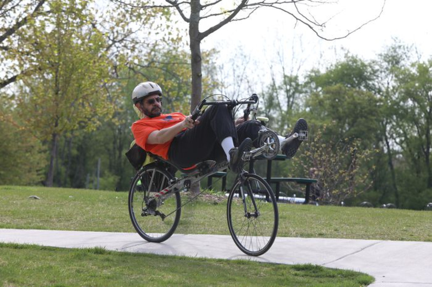 Pancella rides a bike laying on his back.