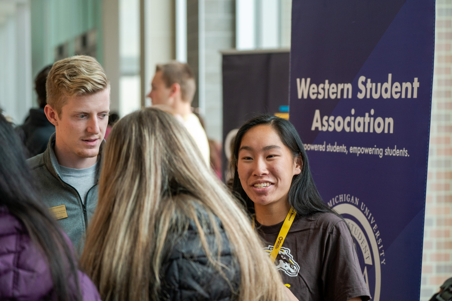 Students talk in front of a Western Student Association sign.