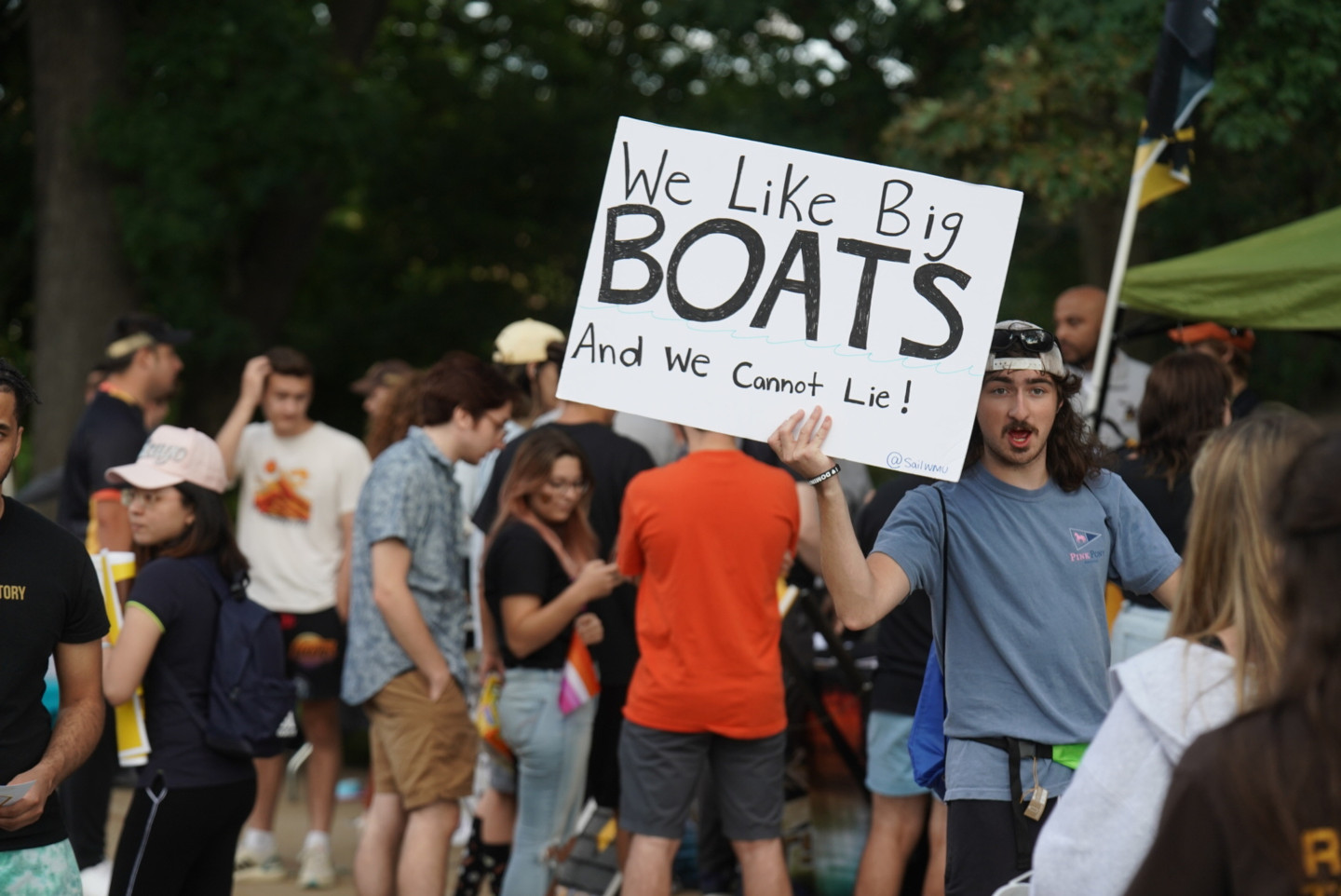 A student carries a sign that says, "We like big boats and we cannot lie!"