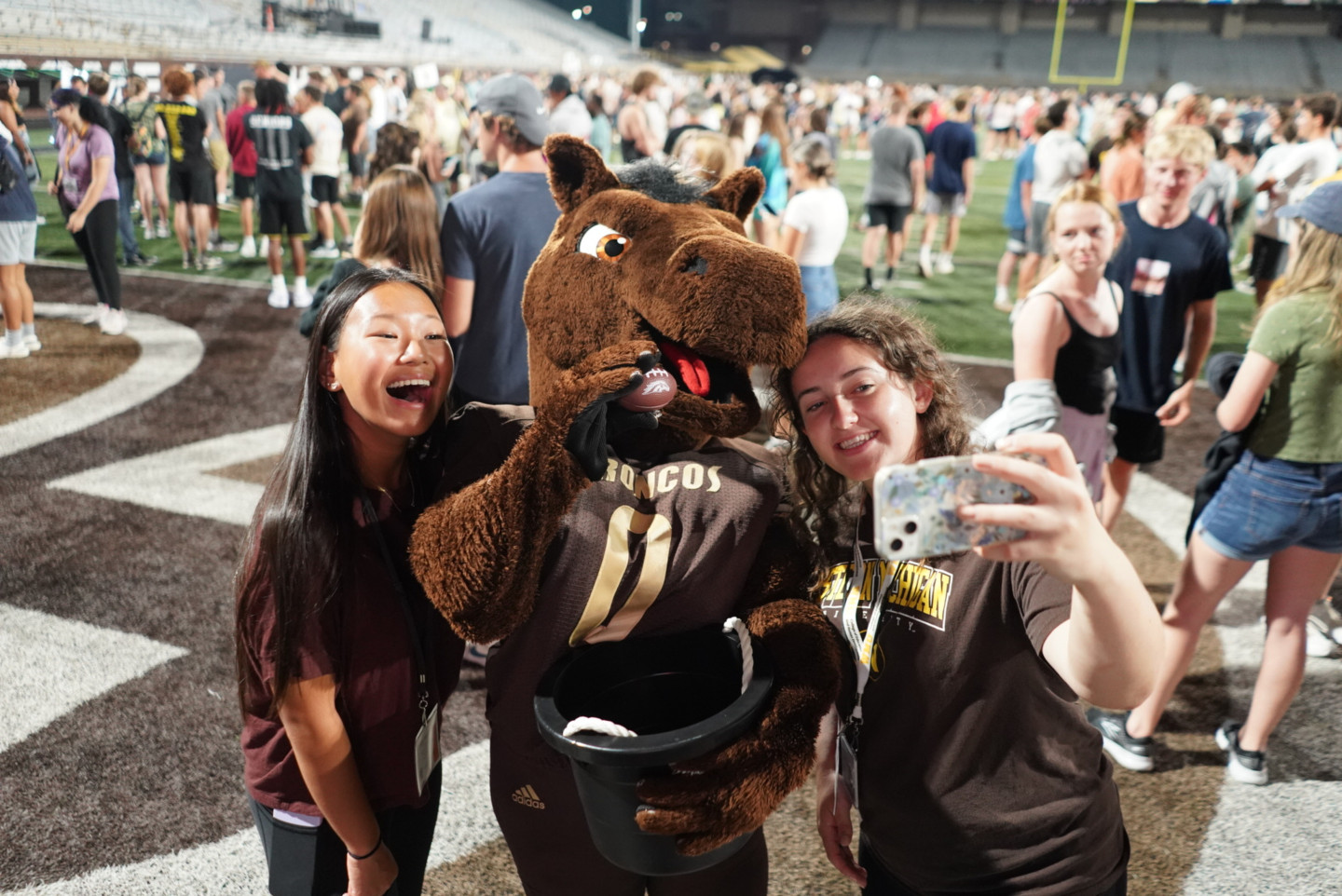 Students take a selfie with Buster Bronco.