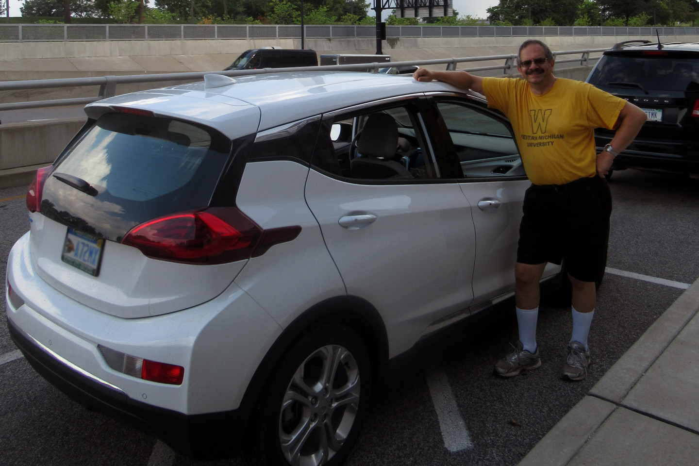 Paul Pancella stands next to a white car.