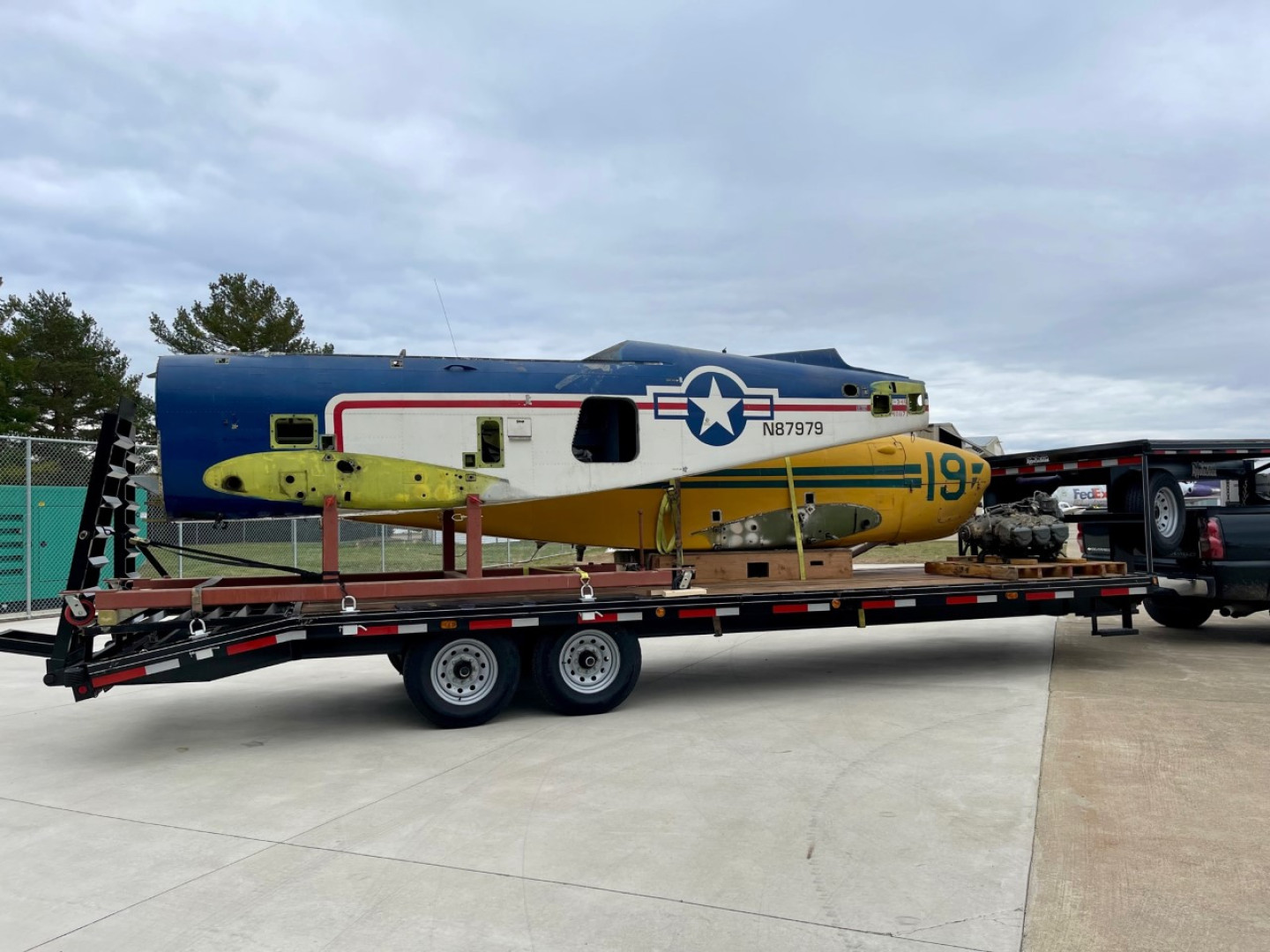 The bodies of two small planes sit on a truck bed.