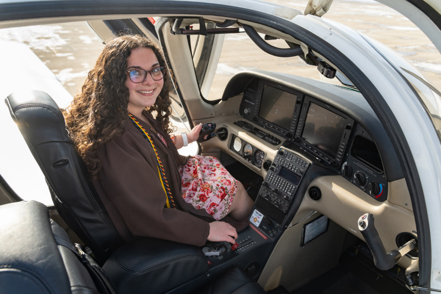 Emily Hartzell sits in the cockpit of an airplane.