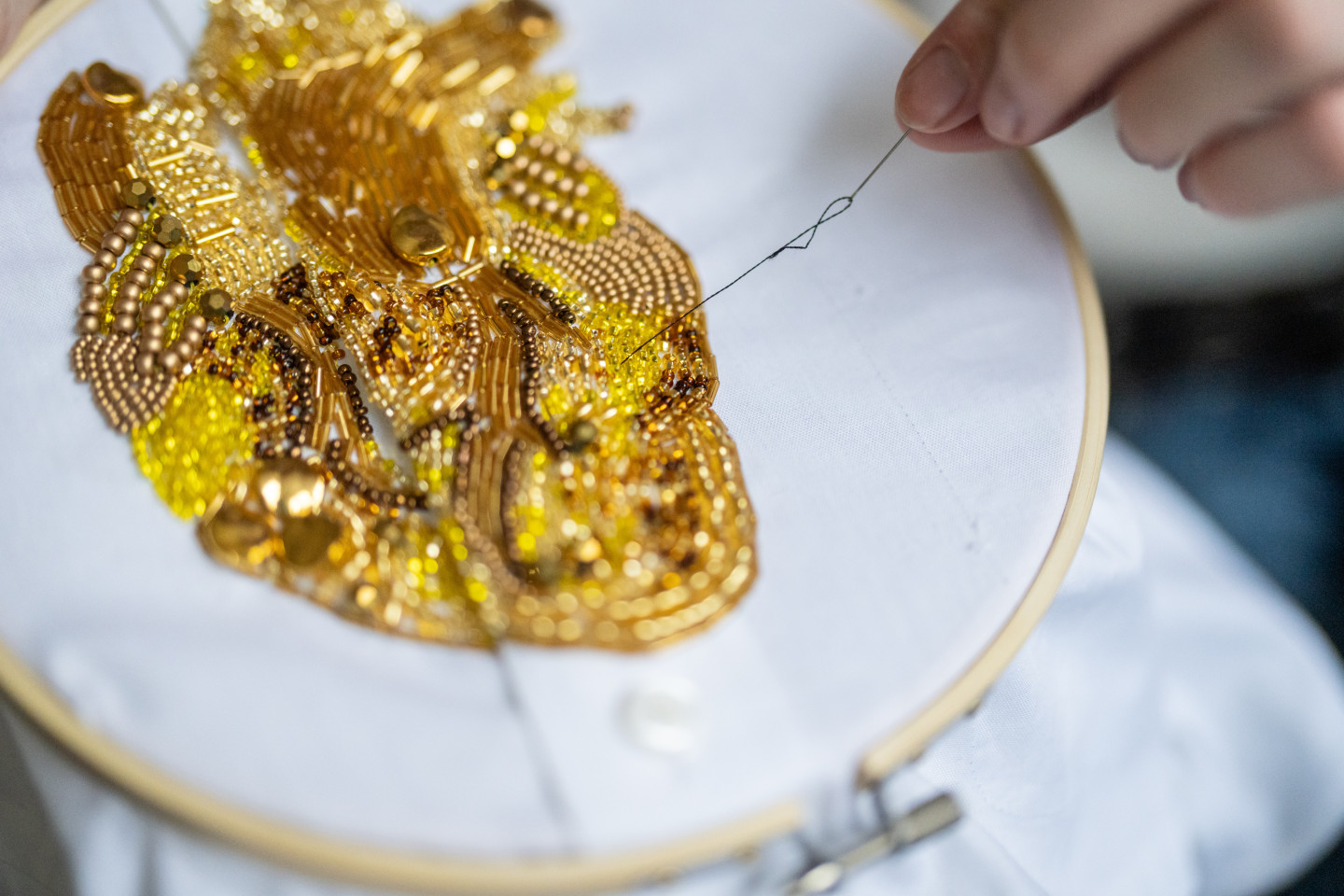 A close up shot of a heart made from hundreds of golden beads.