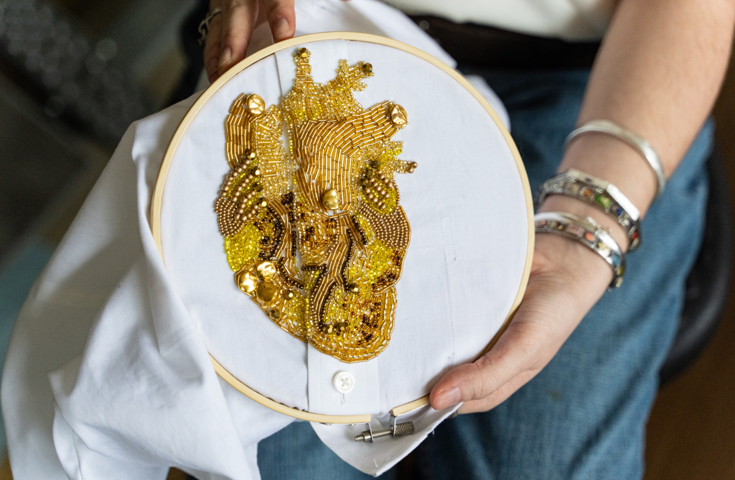 A close-up photo of Laura Argentati's golden beaded heart design.