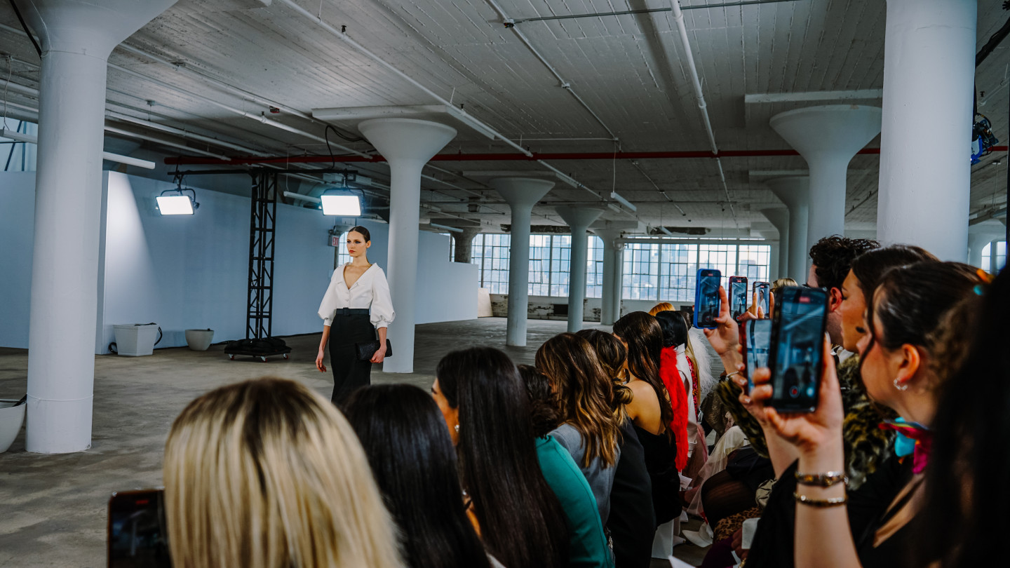 A model walks down a runway in an industrial setting.