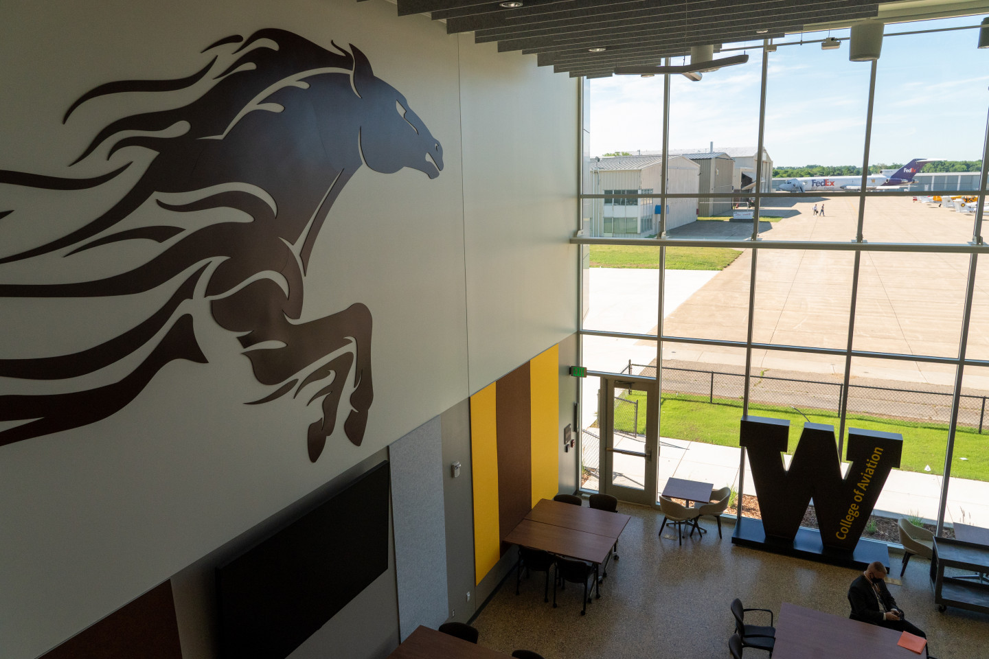 The lobby of the Aviation Education Center featuring a bronco on the wall and a W in the window.