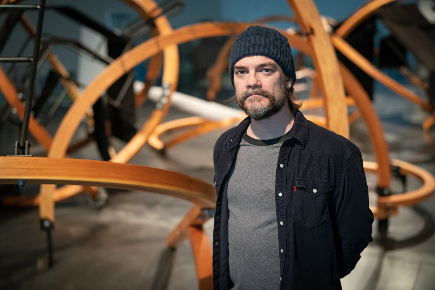 Artist Patrick Wilson stands in front of his sculpture "Black Tent Transit."