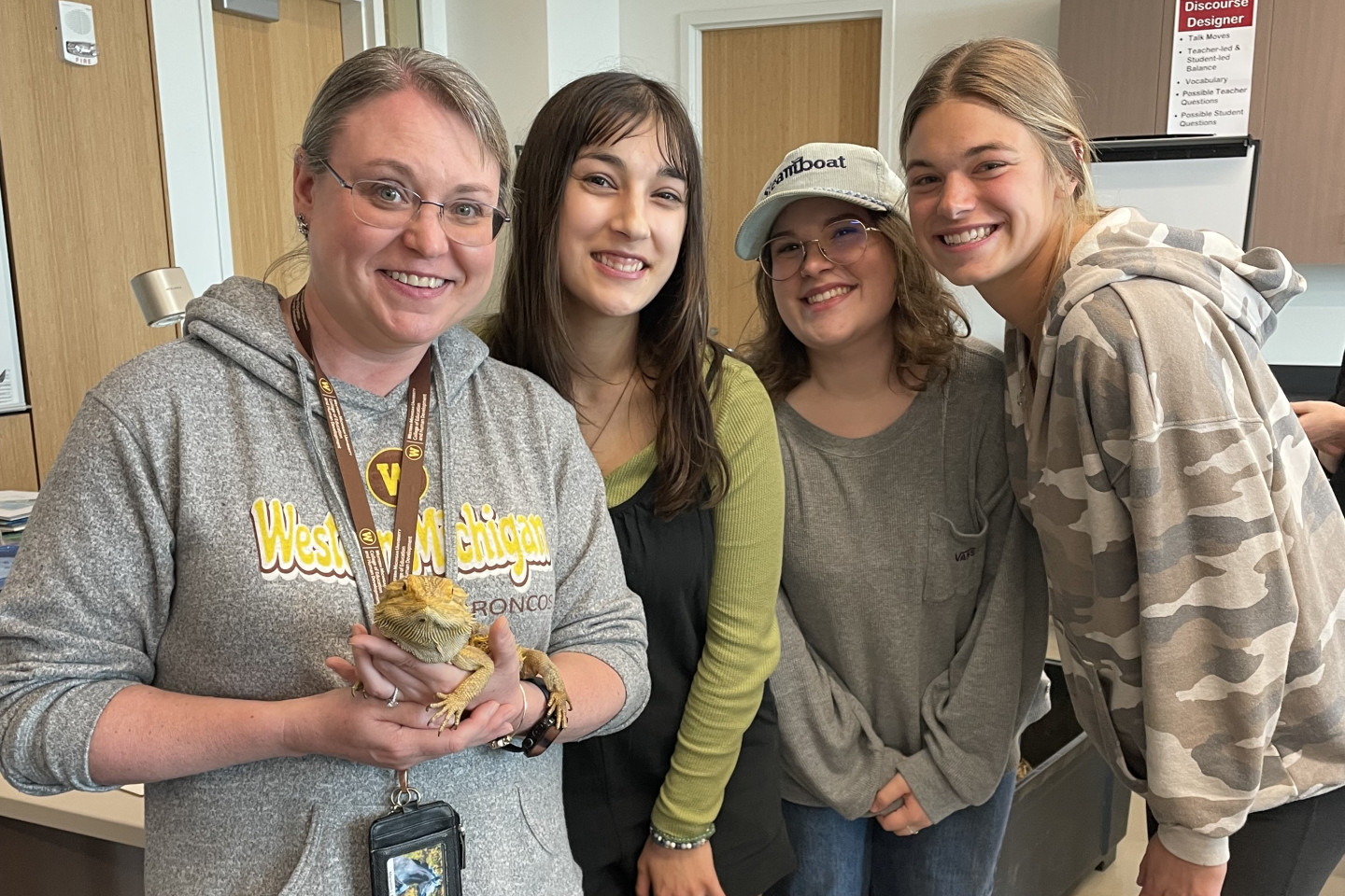 Students with teacher hold lizard