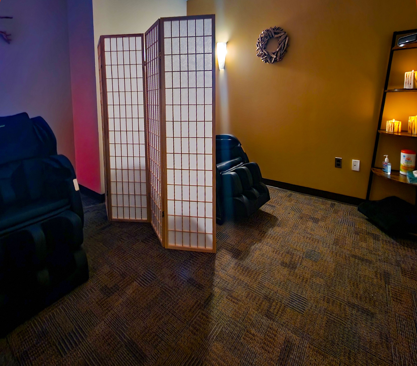 View of room with two massage chairs and artificial candles.