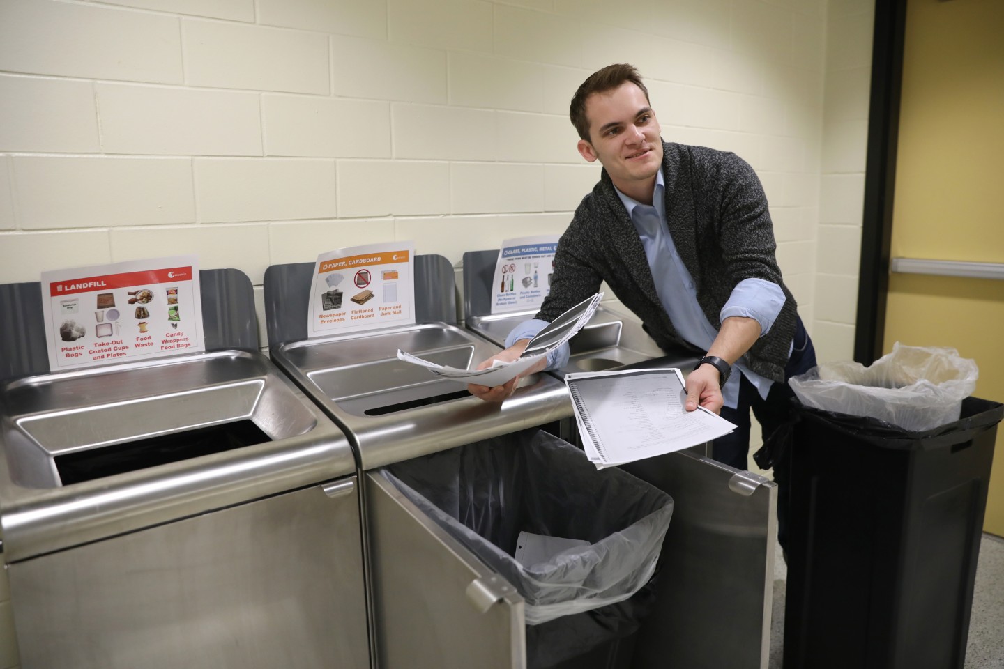 Josh Turske pulls papers out of a recycling bin.