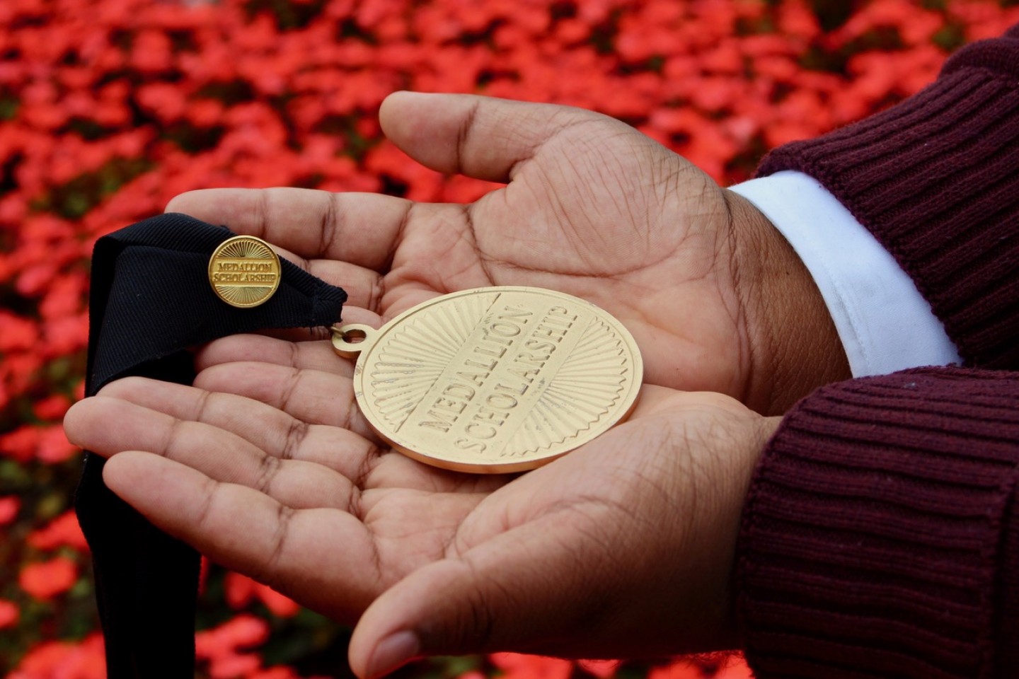 Hands holding a Medallion Scholarship medal