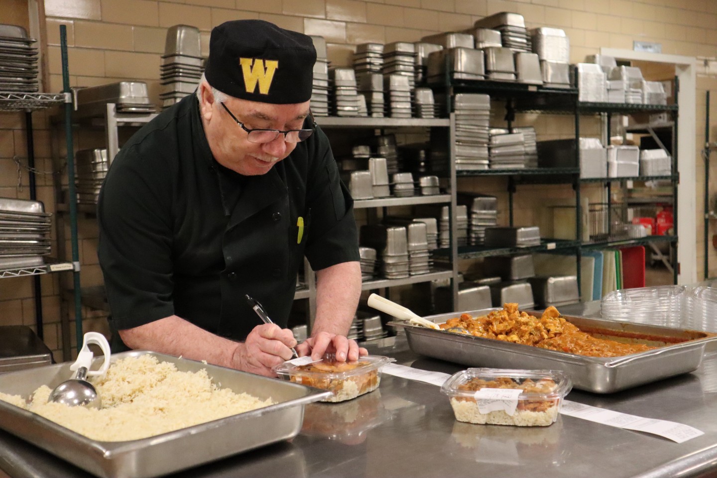 Rob Powers labels a meal that he packaged for the Invisible Need Project.