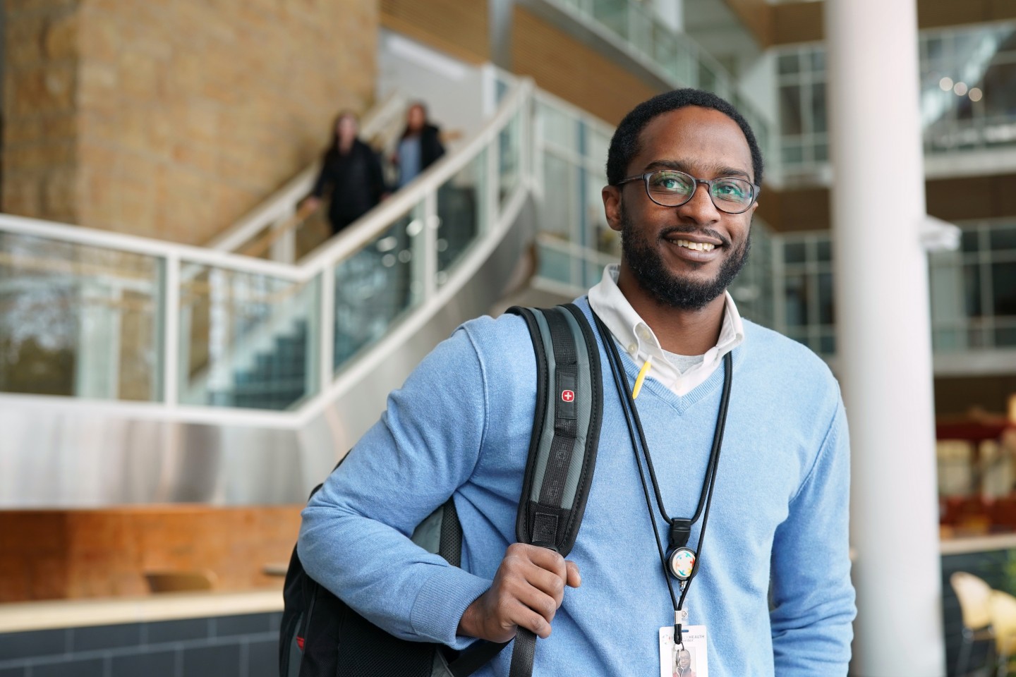 Johnny Anderson III stands with his backpack in the atrium of the College of Health and Human Services.