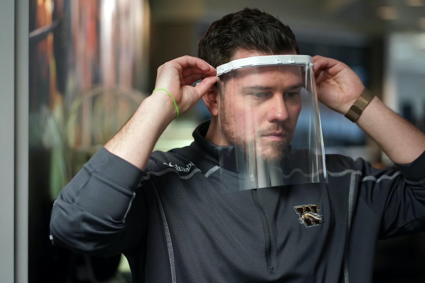 A Western Michigan University worker models a face shield produced for healthcare workers.