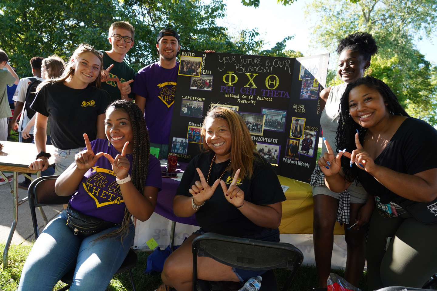 Members of a co-ed business fraternity pose together.