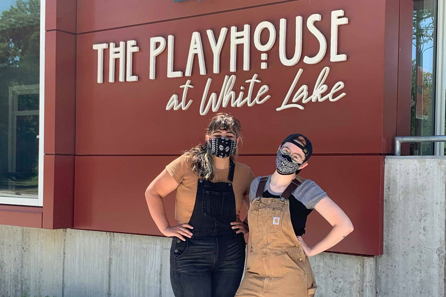 Caroline Arana and Claire Beaman stand together in front of the Playhouse at White Lake sign.