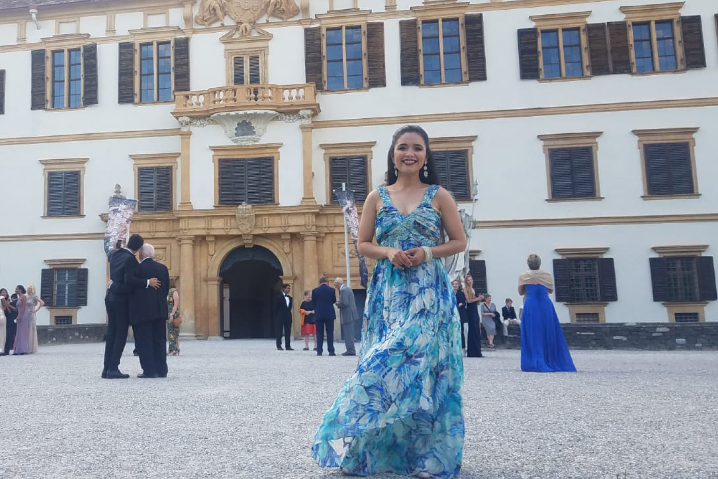 Daniela Peña Cabreja stands in front of an opera house.