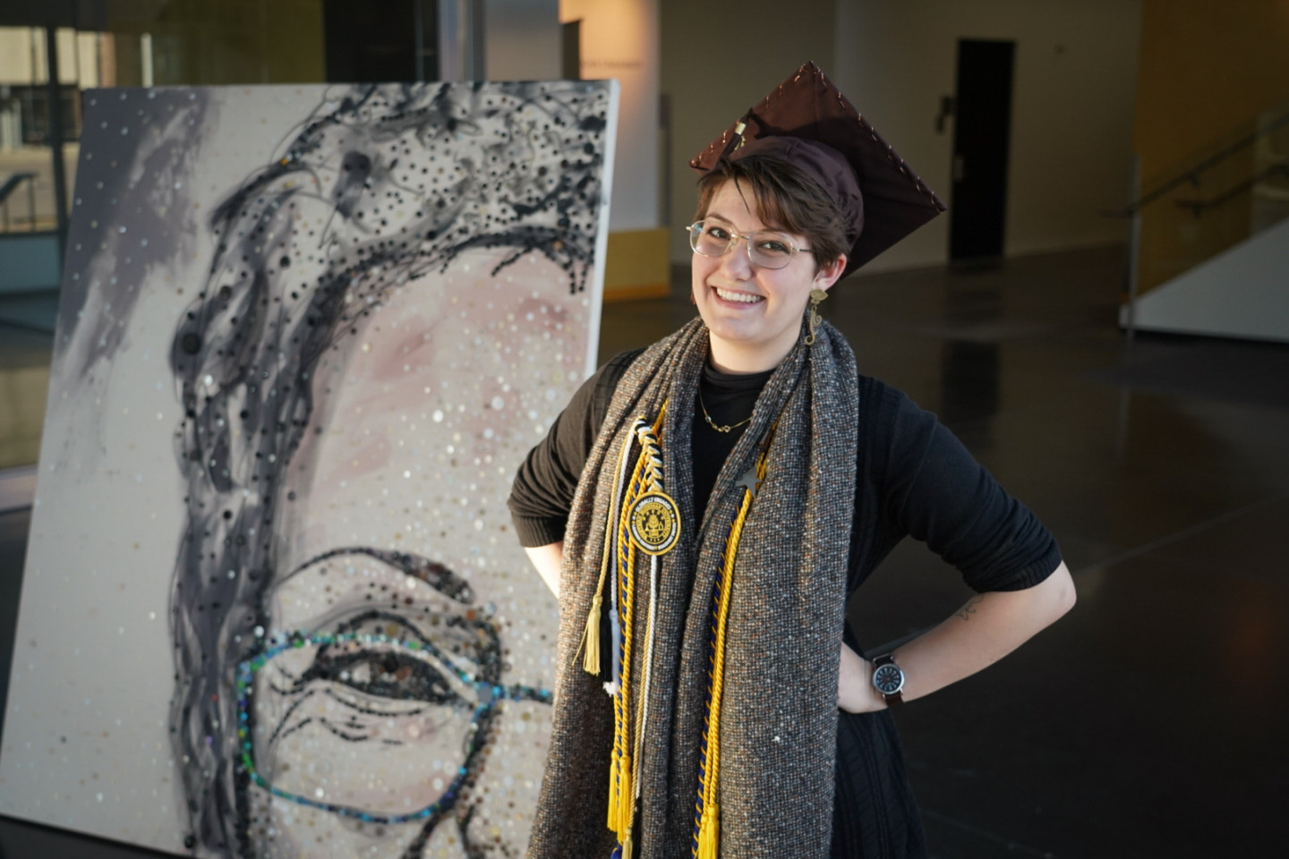 Rozlin Opolka stands in front of a painting she created of her grandmother.
